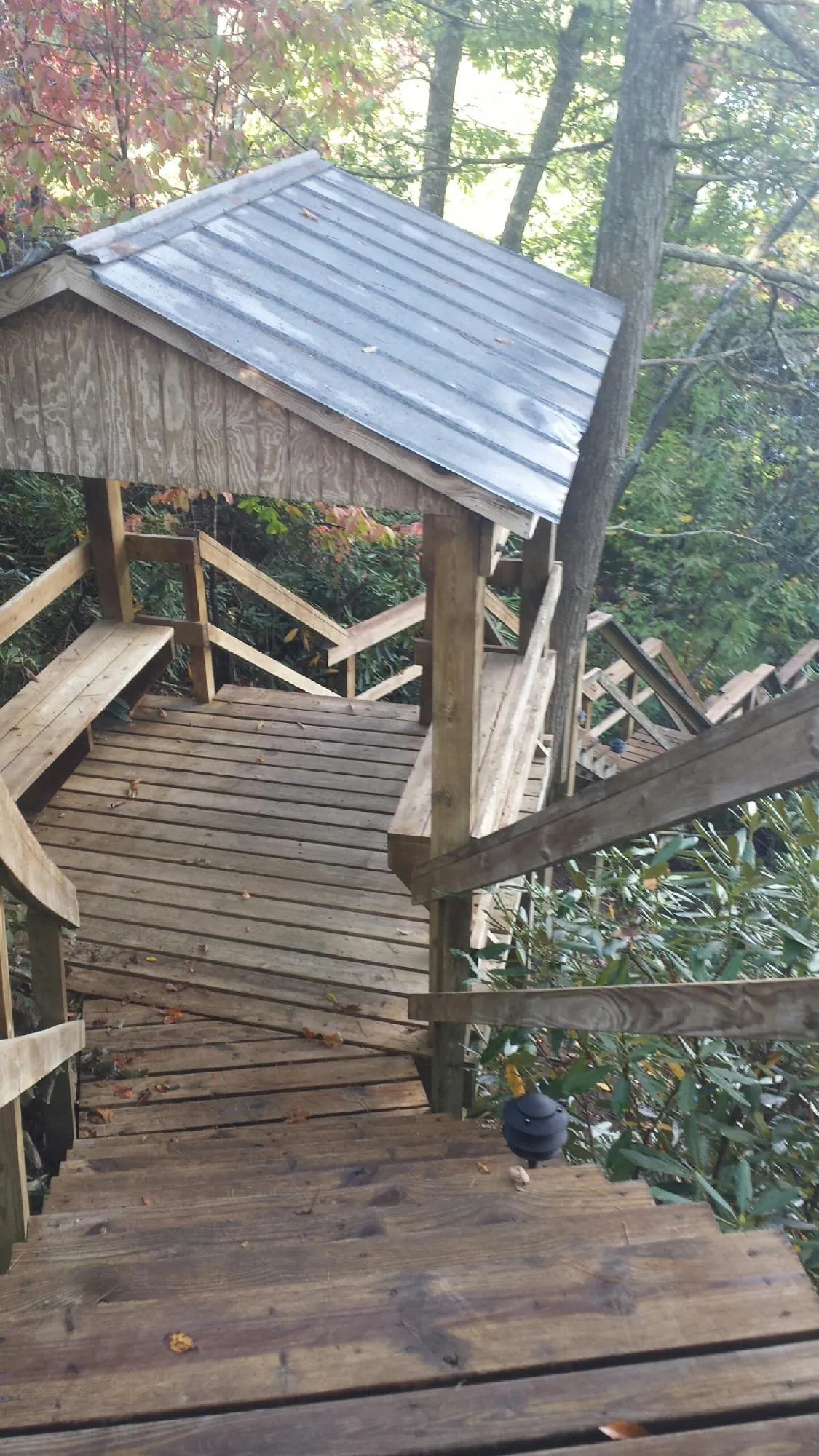 Metal roofed shelter over wooden steps on a wooded walkway — Skylight Repair & Installation work by our crew in Joppa